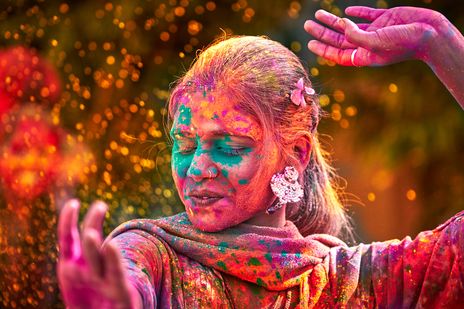 Eine Frau tanzt während des Holi-Farbrausch-Festes