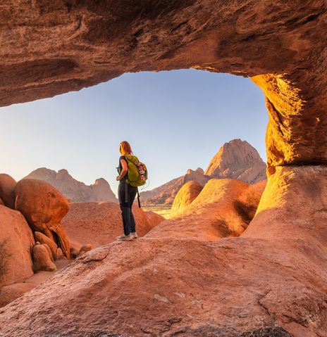Frau steht auf einem Felsen am Spitzkoppe in Namibia