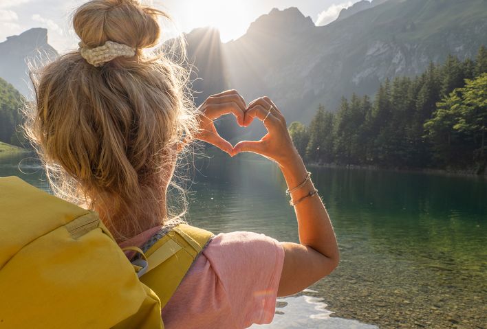 Frau beim Wandern faltet aus Händen ein Herz