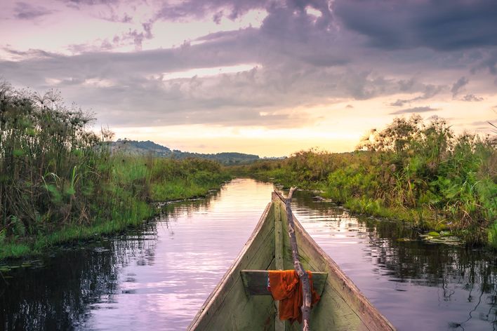 Holzkanus auf einem Fluss in Uganda zur Abenddämmerung