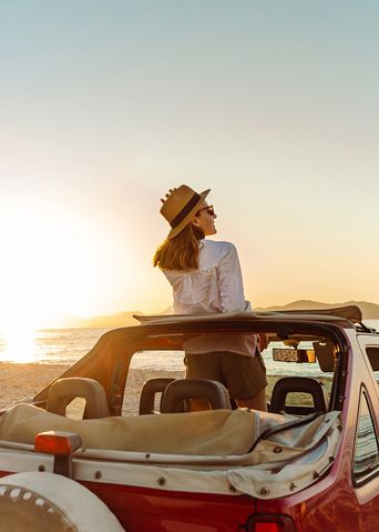 Frau im Auto am Strand