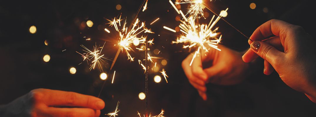 Menschen halten Wunderkerzen in den Händen