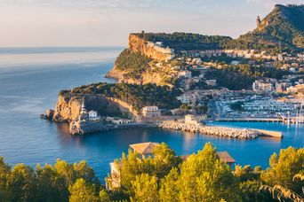 Hafen von Port de Sóller auf Mallorca mit Bucht, Booten und Bergkulisse im Abendlicht