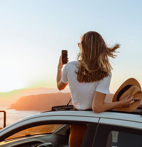 Frau macht ein Foto aus dem Auto 