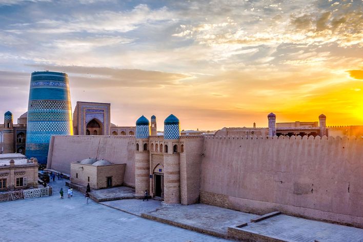 Altstadt von Chiwa in Usbekistan bei Sonnenuntergang mit Lehmhäusern und Stadtmauer