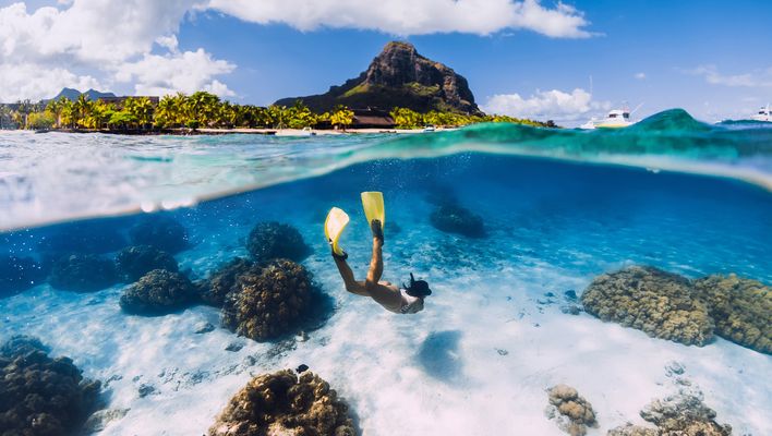 Frau taucht mit Schnorcheln und Flossen im Meer bei Mauritius