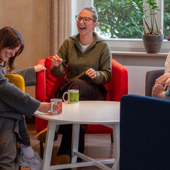 Eine Gruppe von Kolleginnen hat Spaß während der Mittagspause in der Kantine