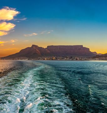 Blick vom Schiff auf Kapstadt mit Tafelberg bei Sonnenuntergang