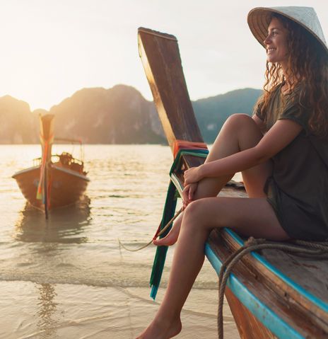 Frau sitzt auf Boot in Thailand
