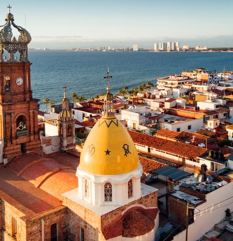 Blick auf die Altstadt von Puerto Vallarta mit einer Kirche, Häusern und der Küste