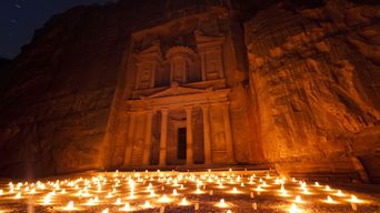 Lichter vor der Felsenstadt Petra in Jordanien in der Nacht