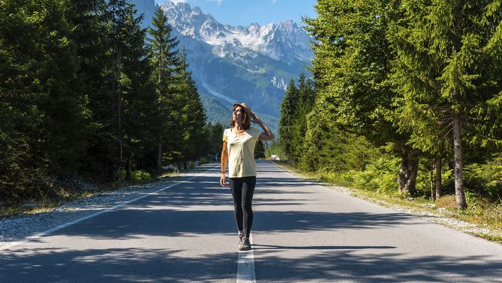 Frau auf einer Straße durch die Berglandschaft des Nationalparks Theth in Albanien
