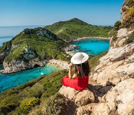 Frau auf Felsen mit Blick auf Meer