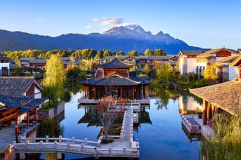 Ein traditionell chinesisches Gebäude in Lijiang mit dem Yulong Xueshan Berg im Hintergrund