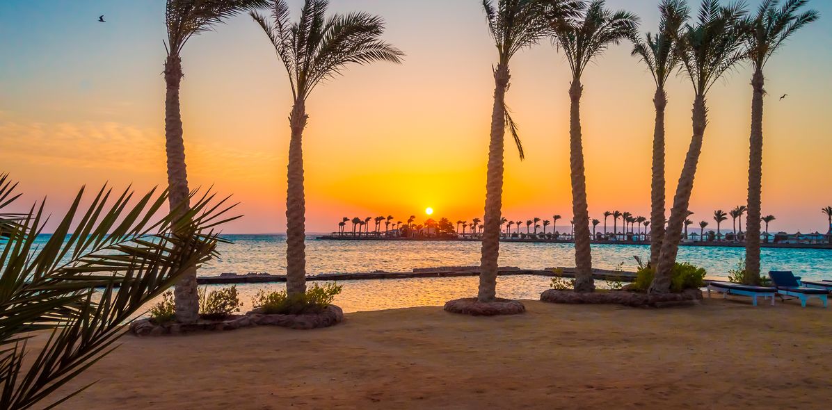 Strand mit Palmen bei Sonnenuntergang