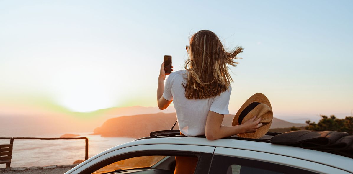 Frau macht ein Foto aus dem Auto 