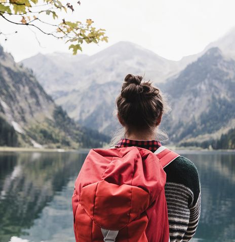 Frau steht an einem Bergsee beim wandern
