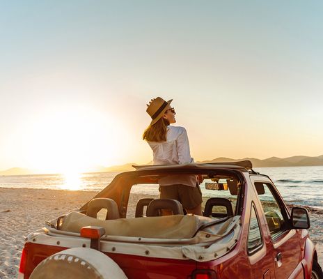 Frau im Auto am Strand