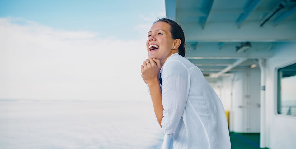 Fröhliche Frau auf Kreuzfahrtschiff