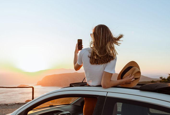 Frau mit Handy im Auto