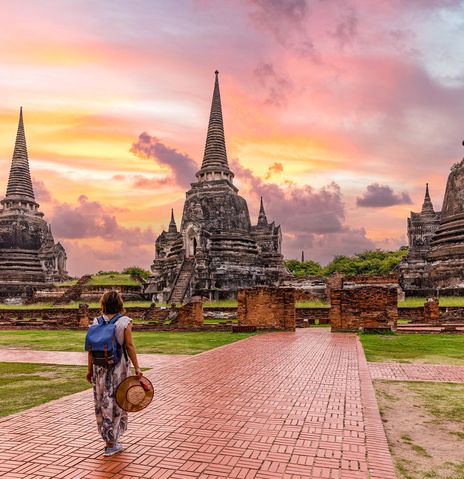 Eine Frau spaziert durch die Tempelanlage von Ayutthaya