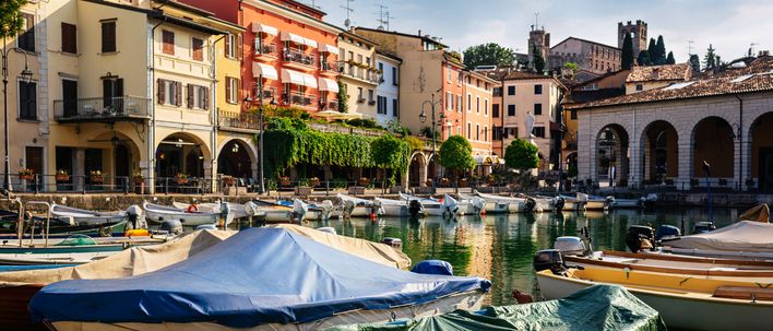 Hafen von Desenzano del Garda mit Booten und Gebäuden am Ufer des Gardasees