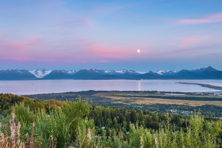 Weite Tundralandschaft in Alaska bei Sonnenuntergang mit Bergen am Horizont