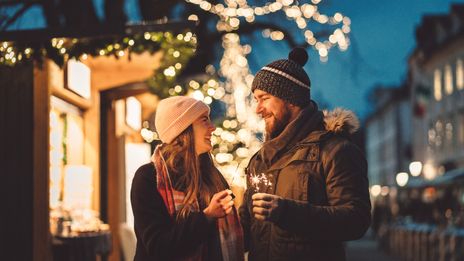 Paar mit Wunderkerzen am Weihnachtsmarkt