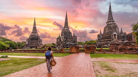 Eine Frau spaziert durch die Tempelanlage von Ayutthaya