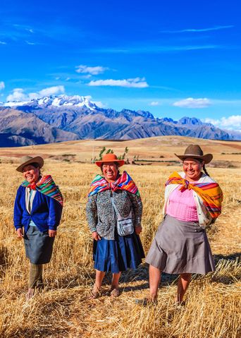 Frauen in traditioneller Kleidung in Peru vor bergiger Landschaft