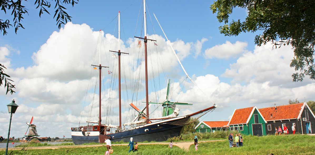 Segelschiff in Holland vor Windmühlen.