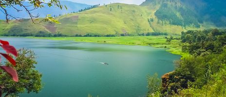 Der Tobasee auf Sumatra mit grünen Hügeln im Hintergrund