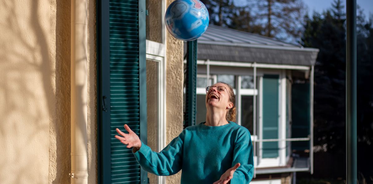 Mitarbeiterin Manuela hat Spaß mit einem Wasserball als Globus