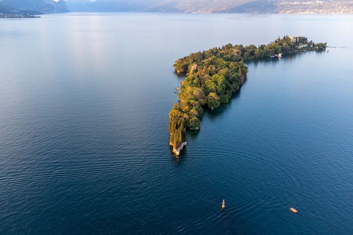 Luftaufnahme der Isola del Garda, einer grünen Insel im Gardasee, umgeben von tiefblauem Wasser
