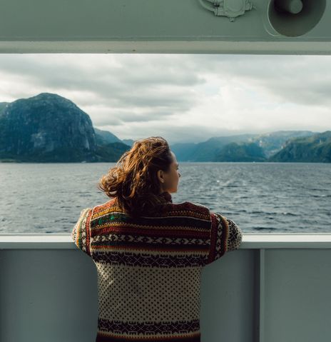 Frau schaut vom Schiff in die Landschaft