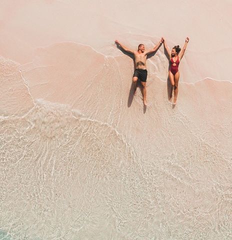Paar liegt am Strand in der Brandung