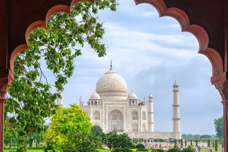 Blick auf den Taj Mahal in Agra durch einen kunstvollen Torbogen