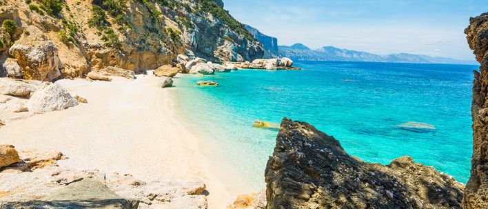 Küstenlandschaft auf Sardinien mit grünen Hügeln und Meer