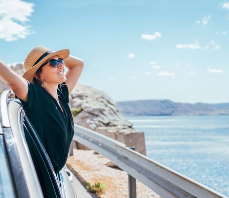 Frau im Auto am Meer