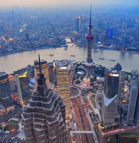Vogelperspektive auf die Metropole Shanghai mit Blick auf den Huangpu Jiang im Sonnenuntergang