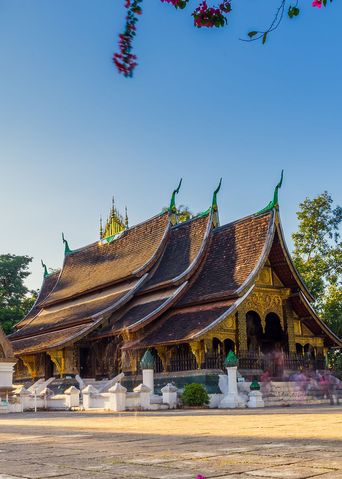 Traditioneller Tempel in Luang Prabang mit kunstvoller Architektur und Palmen