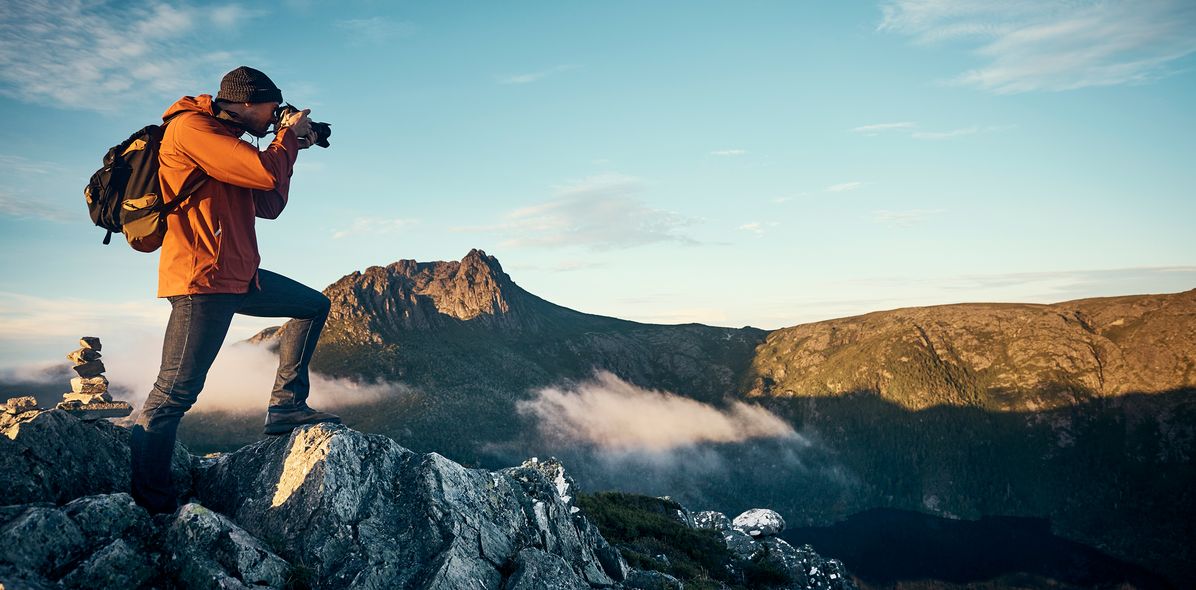 Mann fotografiert Ausblick auf einem Berg