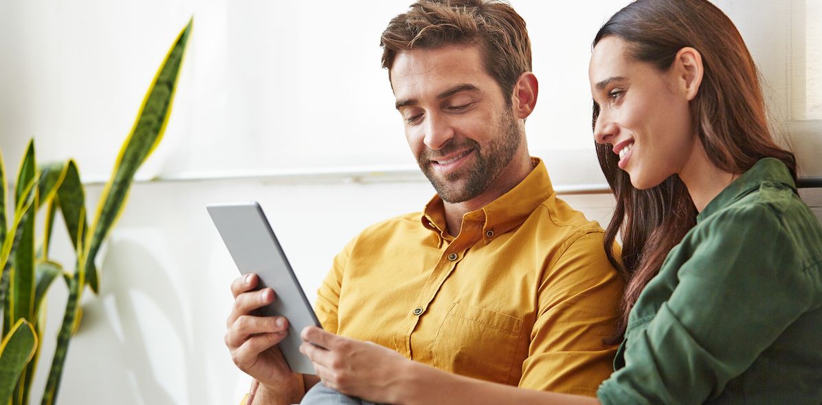 Paar mit Tablet auf dem Sofa
