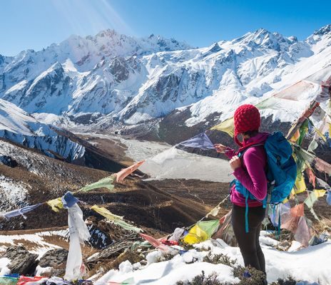 Frau genießt den Ausblick auf die schneebedeckte Berglandschaft in Nepal bei einer Wanderung