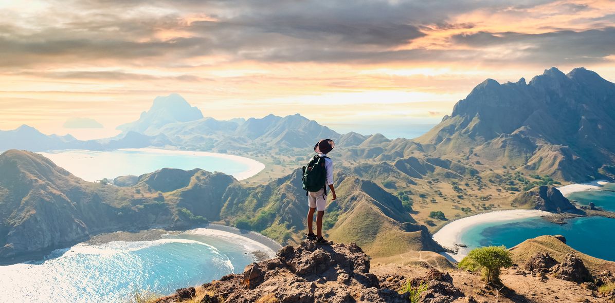 Mann mit Rucksack blickt im Komodo-Nationalpark auf der Insel Padar in Indonesien
