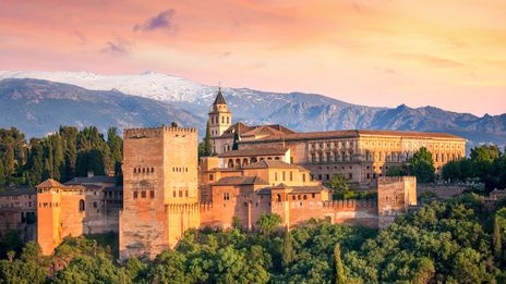Alhambra in Granada im warmen Licht des Sonnenuntergangs vor der schneebedeckten Sierra Nevada