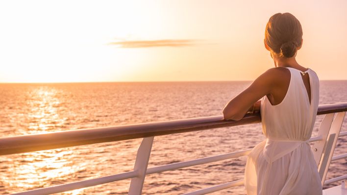 Frau bei Sonnenuntergang auf einem Kreuzfahrtschiff