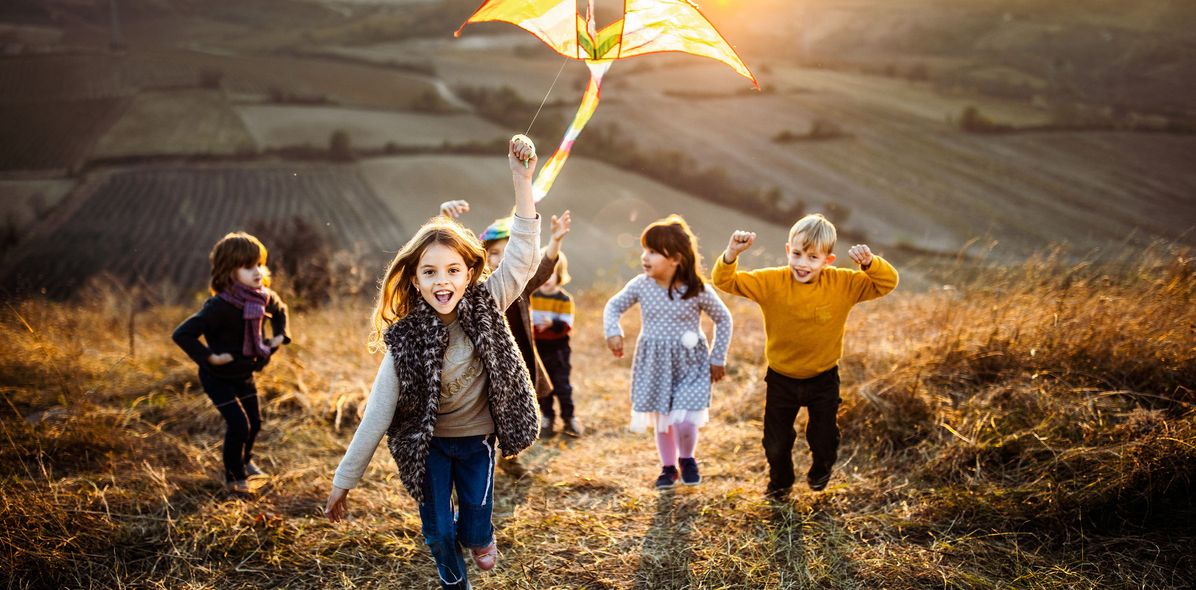 Kinder beim Drachensteigen im Herbst