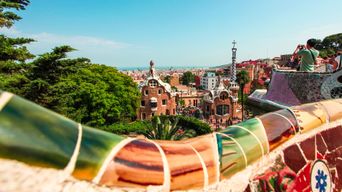 Blick über die Mosaik-Balustrade des Park Güell auf die Gaudi-Häuser und die Landschaft in Barcelona, Spanien