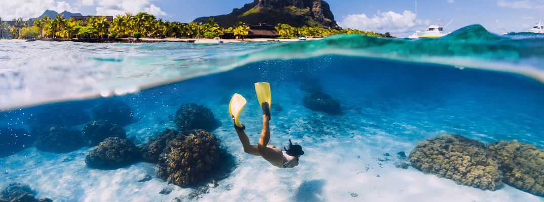 Frau taucht mit Schnorcheln und Flossen im Meer bei Mauritius
